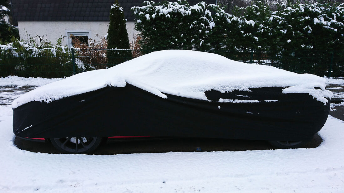 Auto McLaren mit Abdeckplane Autoplane Straßenrand Winter Schnee