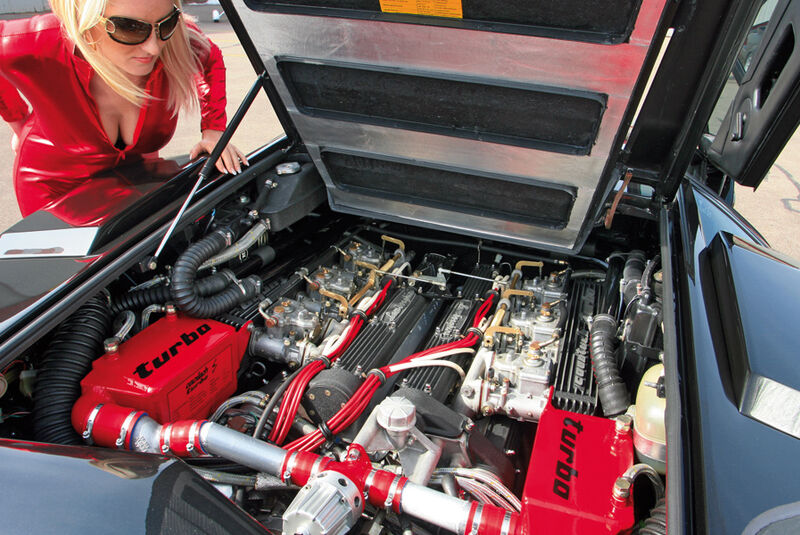 Blondine im Catsuit mit dem V12 des Lamborghini Countach Turbo S - Blick in den Motorraum und den Ausschnitt