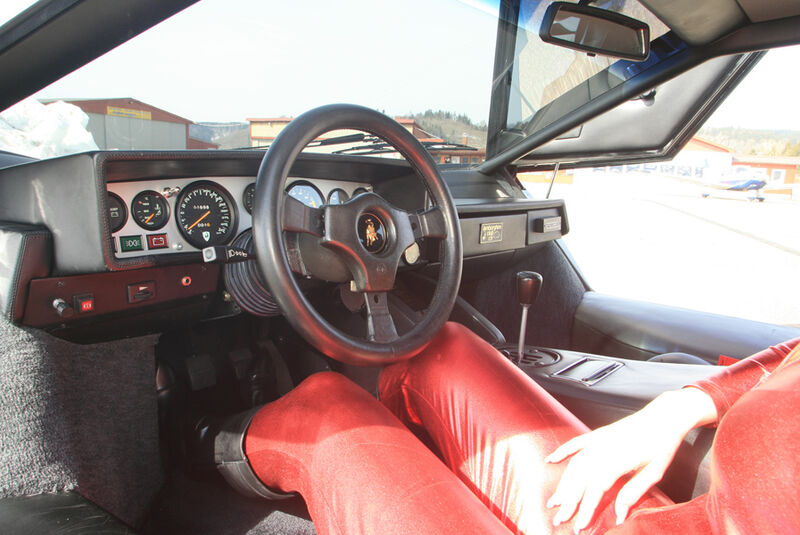 Frau im roten Catsuit im Lamborghini Countach LP 400