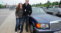 Frau und Mann mit Mercedes 560 SEL