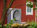 Heat pump on a red holiday home in the summer