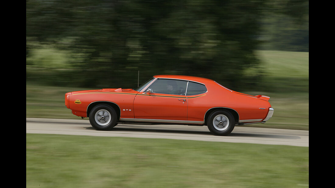 Orangener Pontiac GTO in Fahrt Seitenansicht