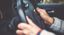 The hand of an elderly gentleman on the steering wheel